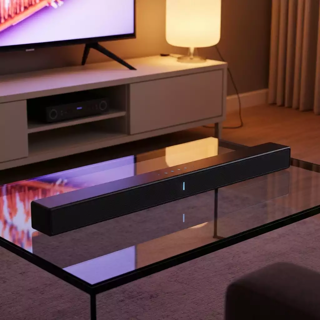 Samsung soundbar with remote control on a modern TV stand, dark environment, soft glow from TV, no text, no words, no typography, clean image
