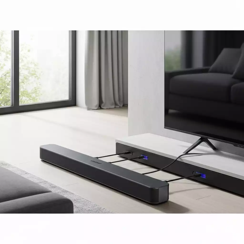 Modern living room with a Samsung soundbar connected to a TV, showing various cables like HDMI and optical, no text, no words, no typography, clean image